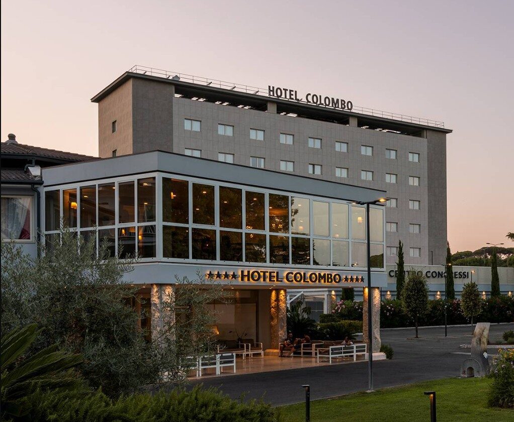 The glass-fronted entrance of the Hotel Colombo at dusk