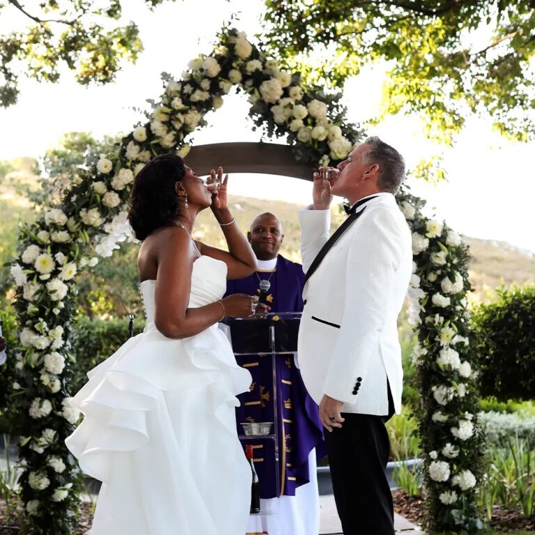 Couple at a floral arch in the gardens, Bona Dea Private Estate
