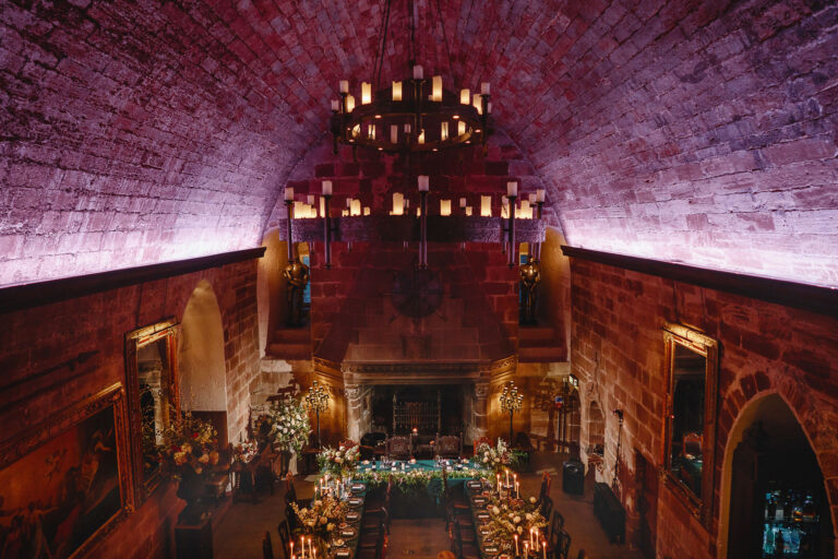 The Great Hall from a raised viewpoint at one end, its high vault washed in soft light over tables set for dinner, Borthwick Castle