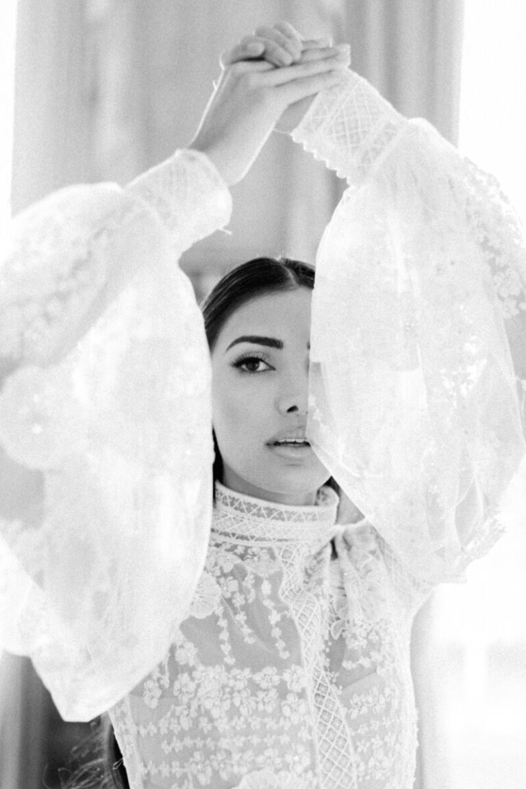 Lace sleeves raised above the head, a veil drawn back behind, Botias