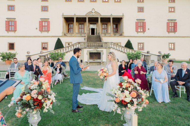 Ceremony on the lawn in front of a villa, with large floral arrangements either side, Bottega dei Fiori by Ezio De Angelis