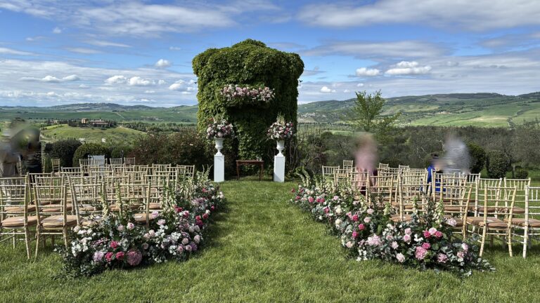 Garden ceremony with flowers lining the grass aisle and a hedge arch ahead, Bottega dei Fiori by Ezio De Angelis