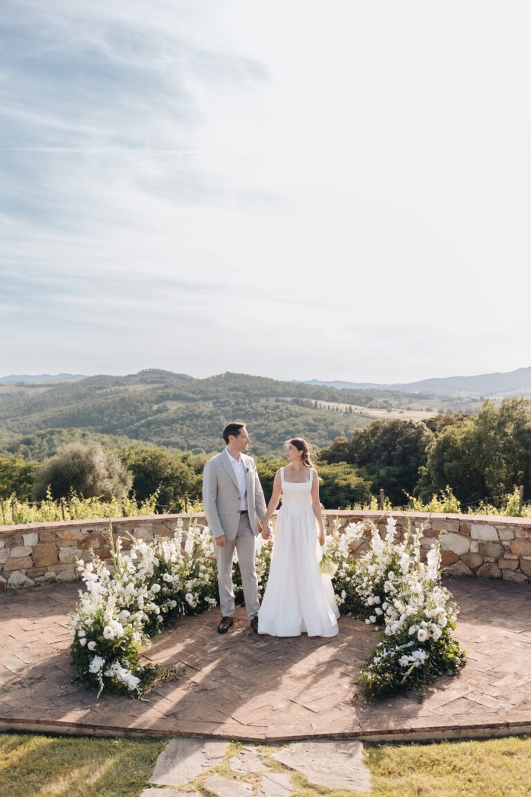 Couple standing in a circle of white flowers on a hilltop terrace, Bottega dei Fiori by Ezio De Angelis