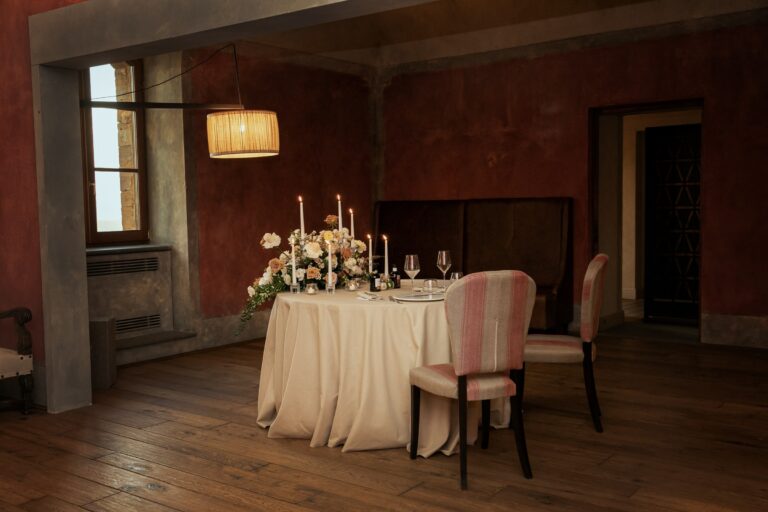 Dinner table for two set with candles and flowers in a frescoed room, Bottega dei Fiori by Ezio De Angelis