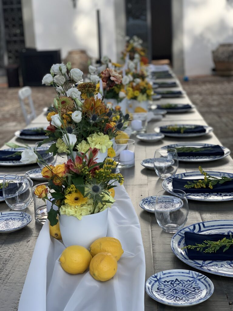 Long table dressed with yellow flowers, lemons and blue and white plates, Bottega dei Fiori by Ezio De Angelis