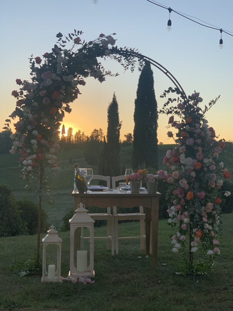 A dinner for two beneath a rose arch at dusk, Bottega dei fiori