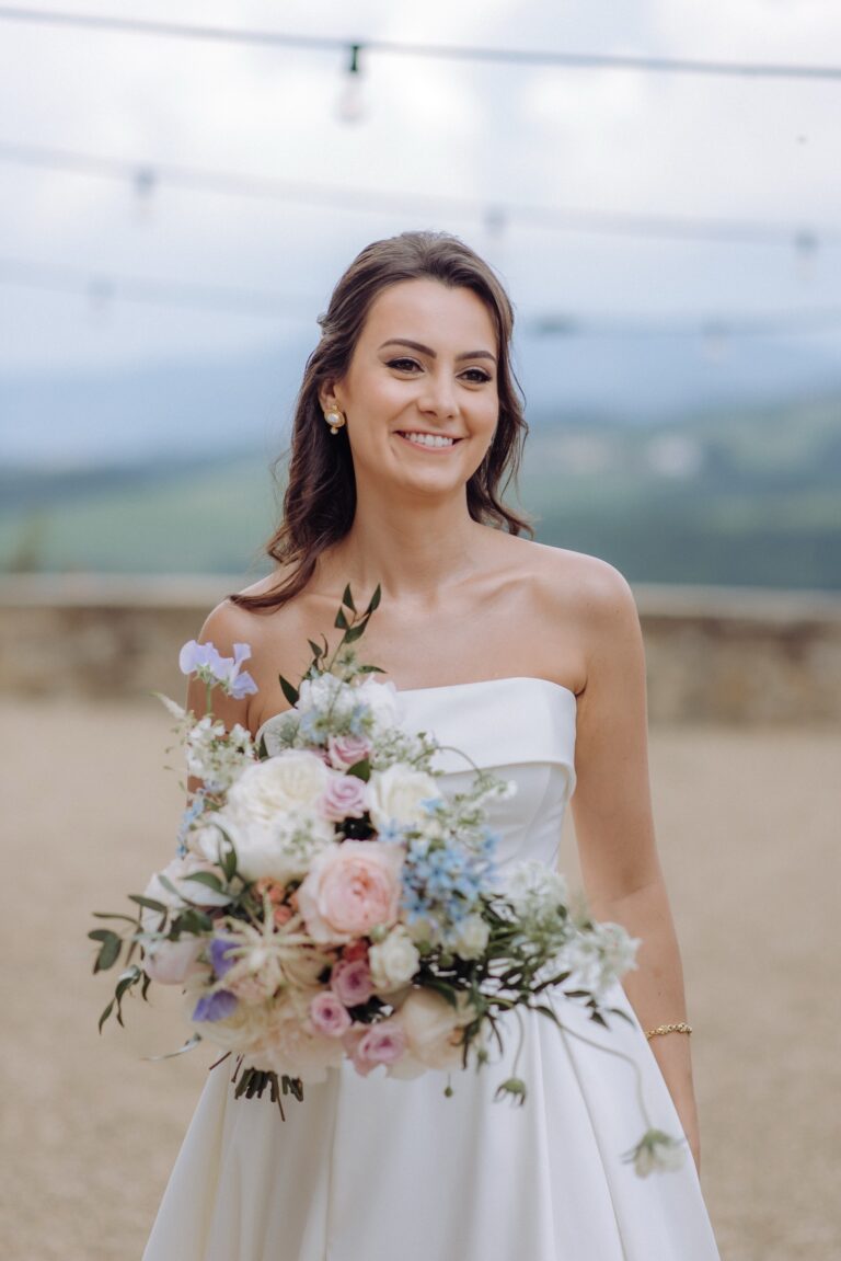 A bride with her bouquet above the Chianti hills, Castello di Gabbiano, Bottega dei fiori
