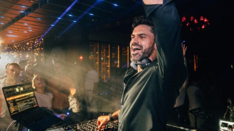 A DJ with arms raised leads a packed dance floor, Box Entertainment