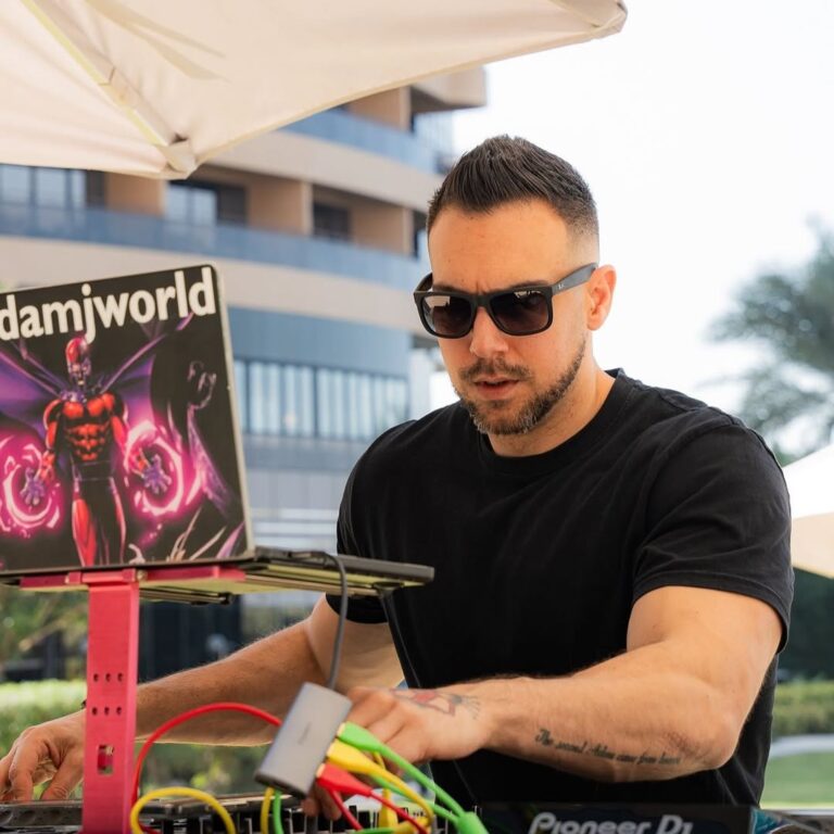 A DJ mixing in the sun with a hotel behind, Box Entertainment