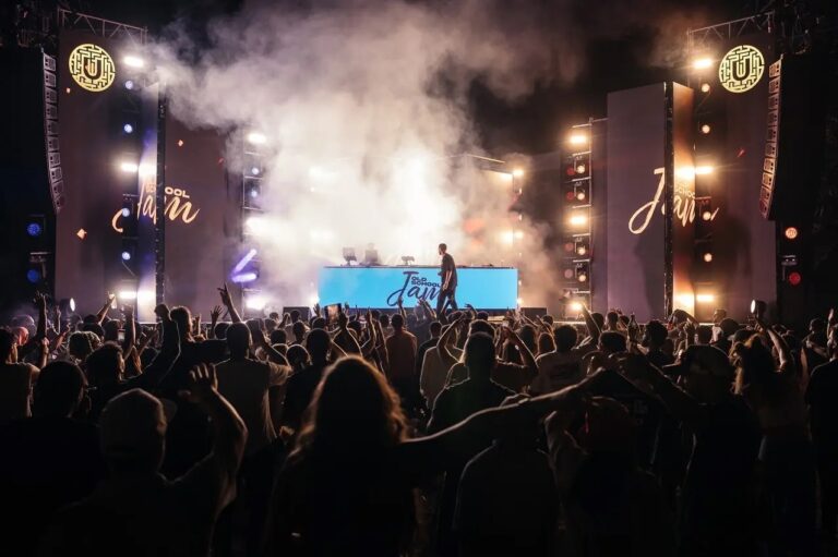 A DJ on a festival stage with smoke and a large crowd, Box Entertainment