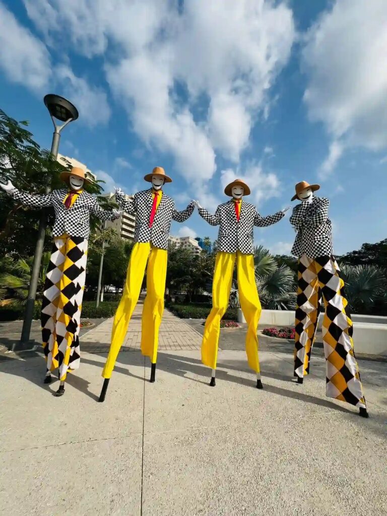 Stilt walkers in harlequin trousers and yellow stockings, Box Entertainment