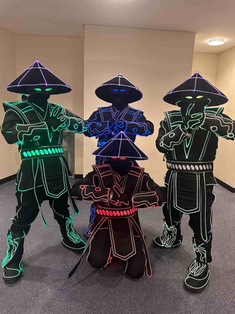 Dancers in light-up costumes kneeling in formation, Box Entertainment