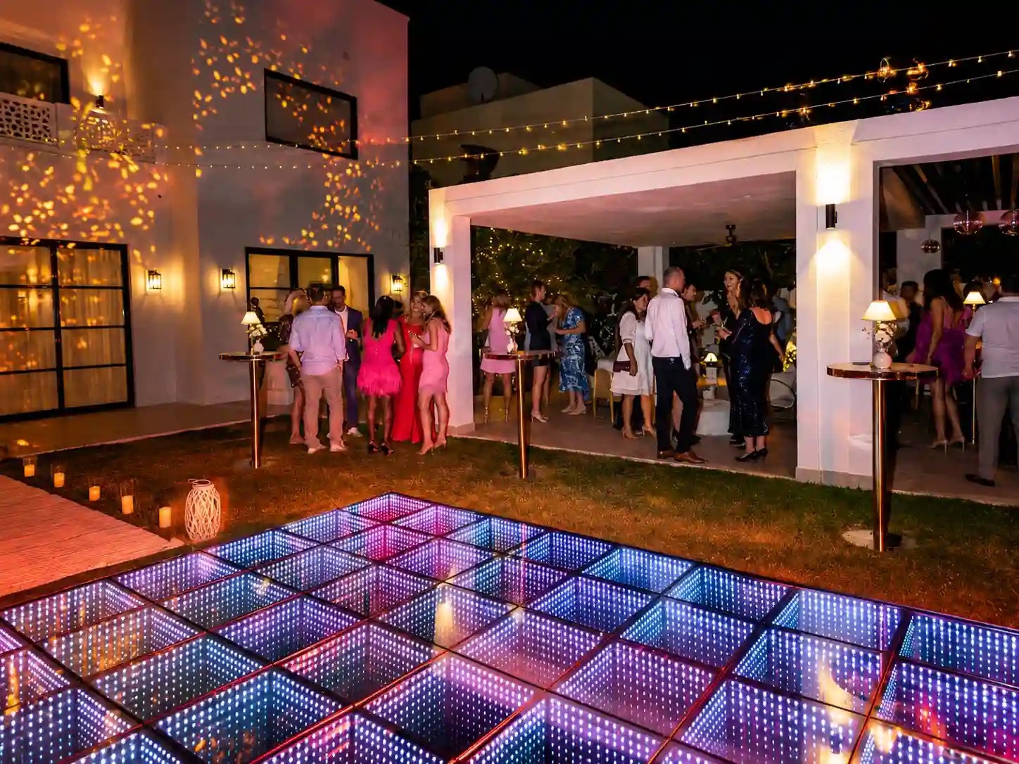 A mirrored LED dance floor glows beside an outdoor reception with festoon lights, Box Entertainment