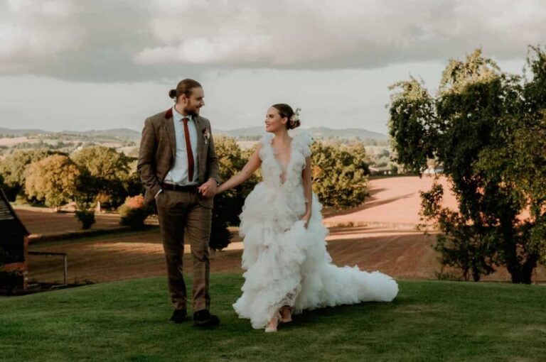 The couple on the estate lawn at golden hour, open countryside beyond, Briery Hill House