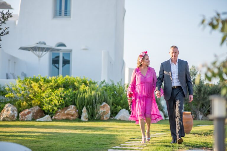 Couple walking through the gardens of a Paros seaside venue, Bright Blue Wedding And Events