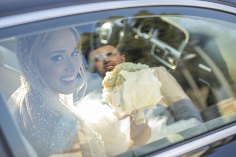 Bride and groom seen through the window of a wedding car, Bright Blue Wedding And Events