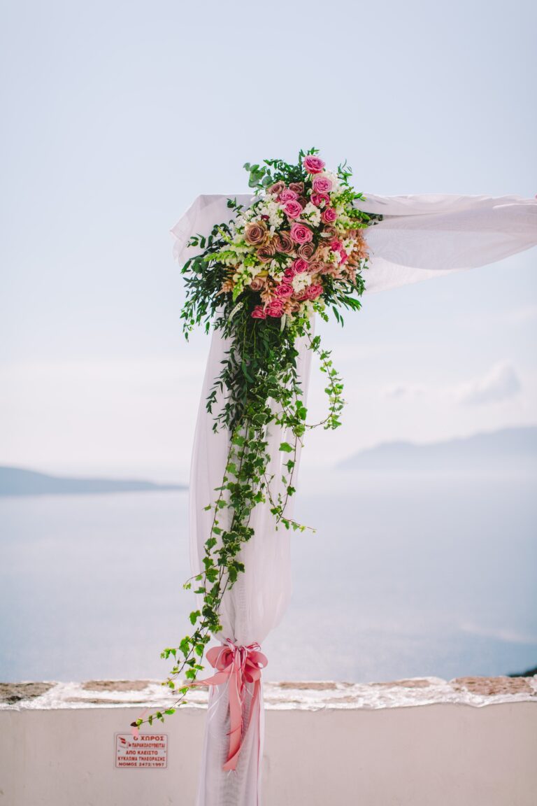 Floral arch with trailing greenery above the Aegean on Milos, Bright Blue Wedding And Events