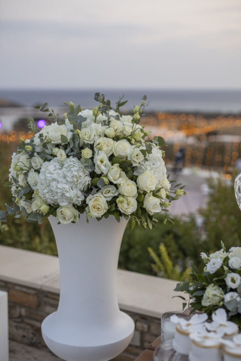 Tall white flower arrangement on a terrace above the sea, Bright Blue Wedding And Events