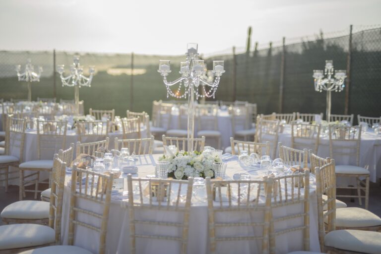 Round tables with candelabras and white flowers in an evening setting, Bright Blue Wedding And Events