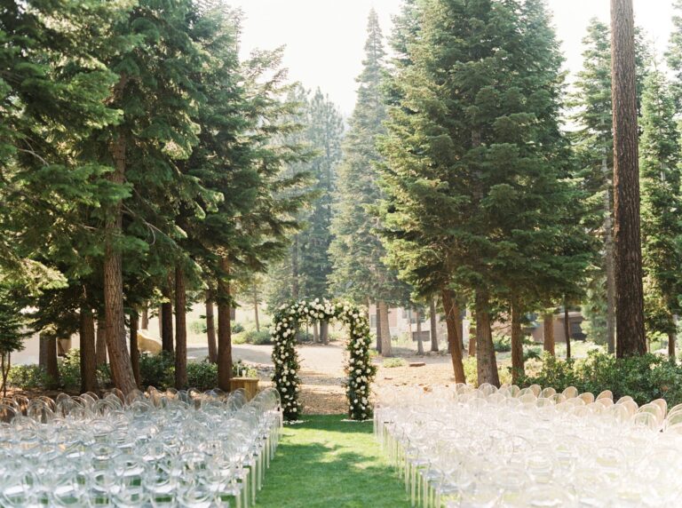 Ceremony seating among pines with a floral arch, Lake Tahoe, Brilliant Event Planning