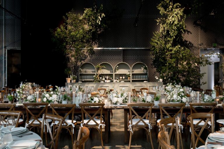 Long tables in a dark gallery with tall greenery, Boston, Brilliant Event Planning