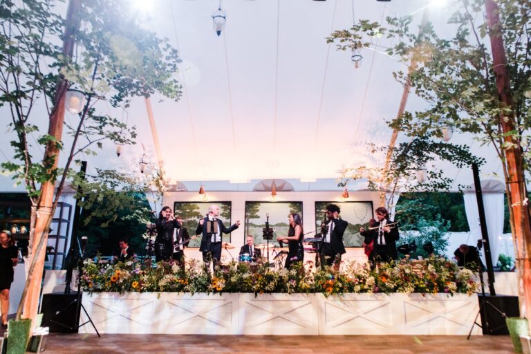 Band on a lit stage in a tent at dusk, Hudson Valley, Brilliant Event Planning