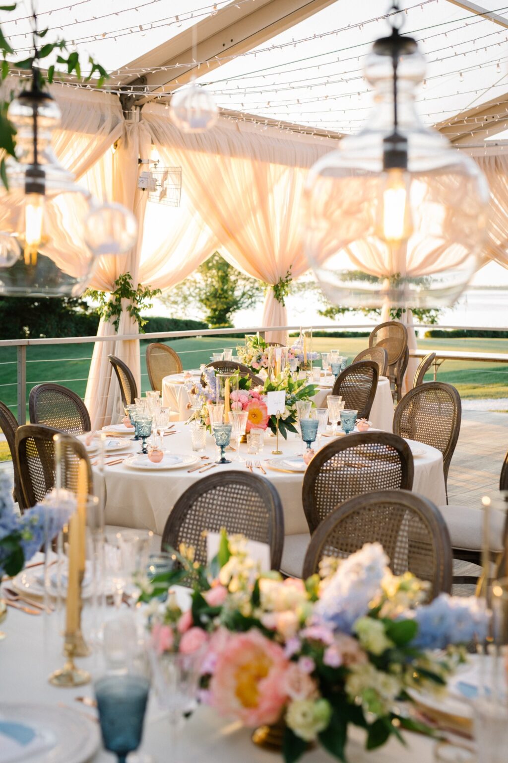 Round table with soft pastel flowers under chandeliers, Newport, Brilliant Event Planning