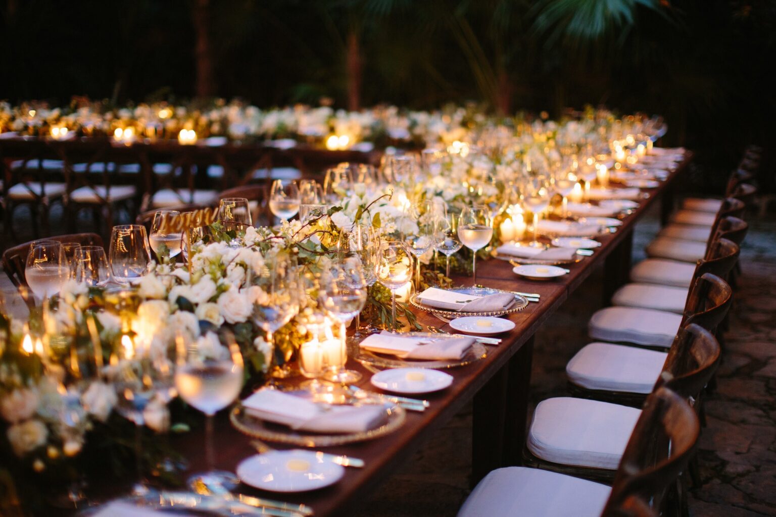 A candlelit long table among trees in the Riviera Maya, Mexico