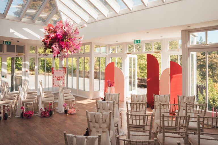 The Orangery dressed with a hot-pink floral installation and red arches, Broadoaks Country House