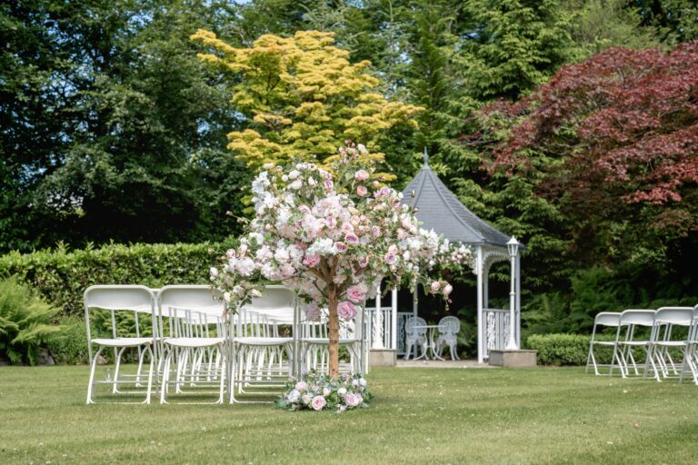 The gazebo dressed with blossom trees, white folding chairs laid out on the lawn, Broadoaks Country House