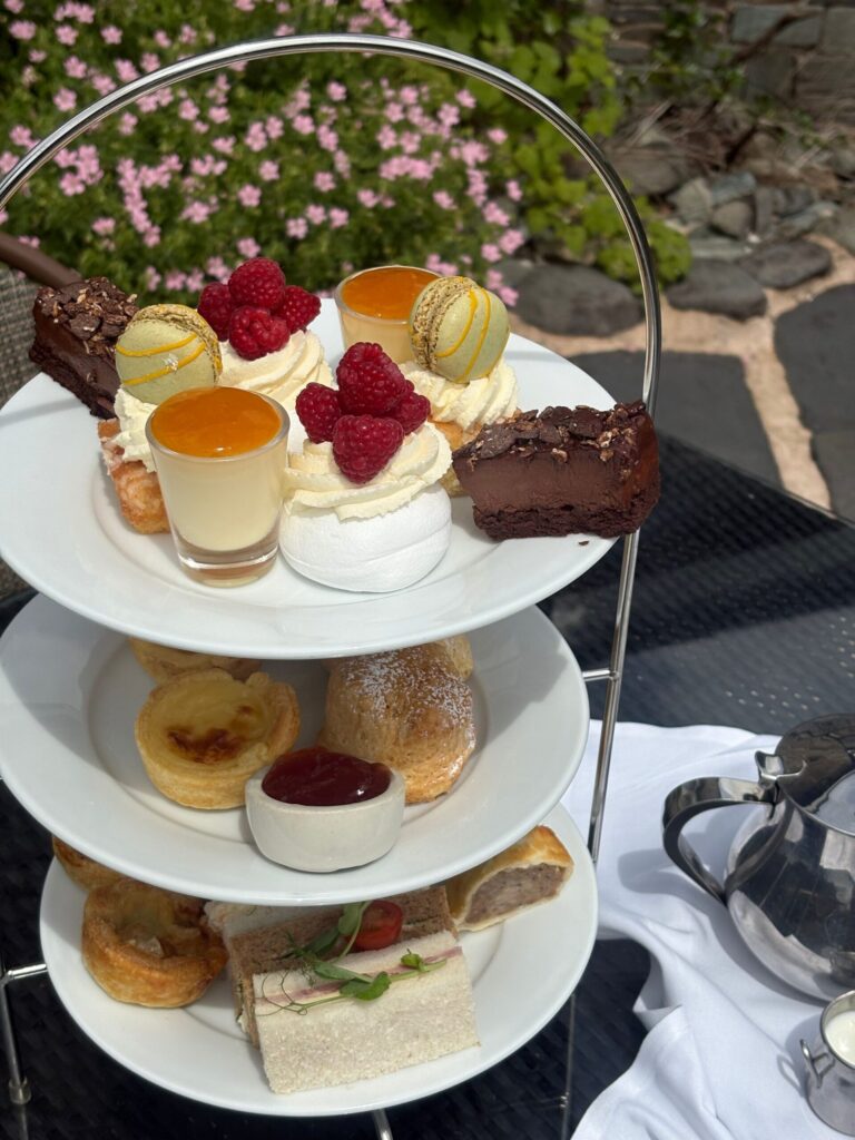 A three-tier afternoon tea stand set out on the lawn, Broadoaks Country House