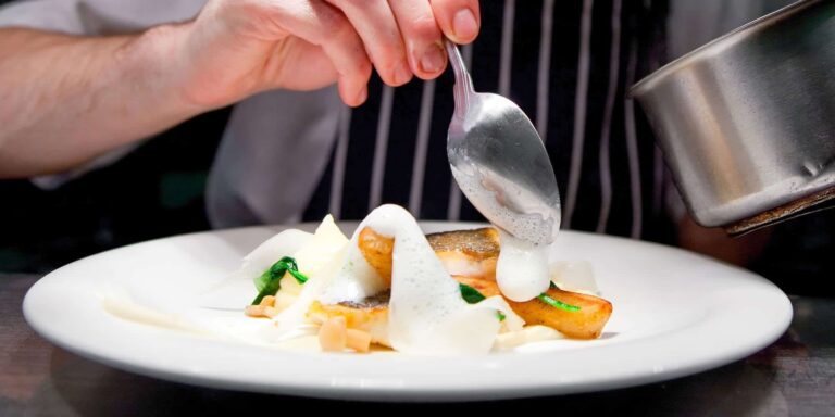 The chef finishing a plated dish at the pass, Broadoaks Country House