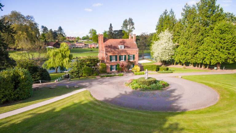 Auberge du Lac, the estate's former hunting lodge, seen from above its circular forecourt with the lake behind, Brocket Hall