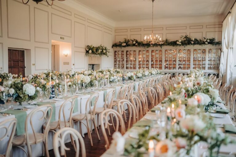 The Ballroom set with long banqueting tables, runners of flowers and candles for a wedding breakfast, Brympton House