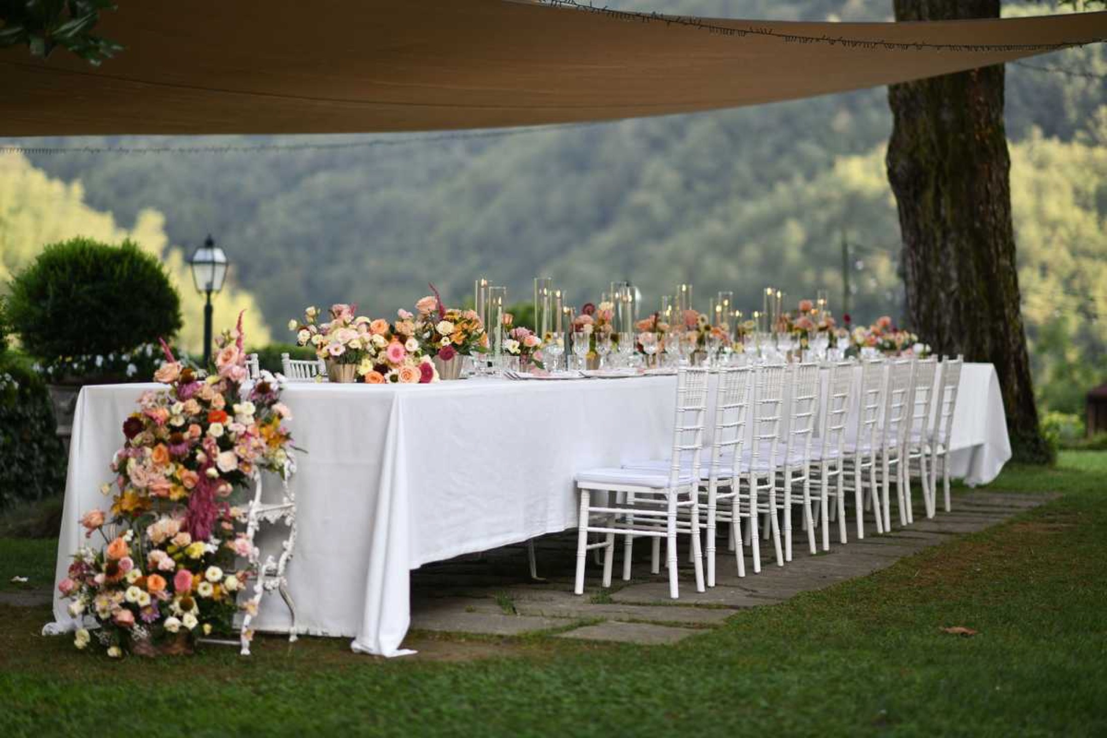 A long table dressed with flowers under the trees, Burlamacchi Villas