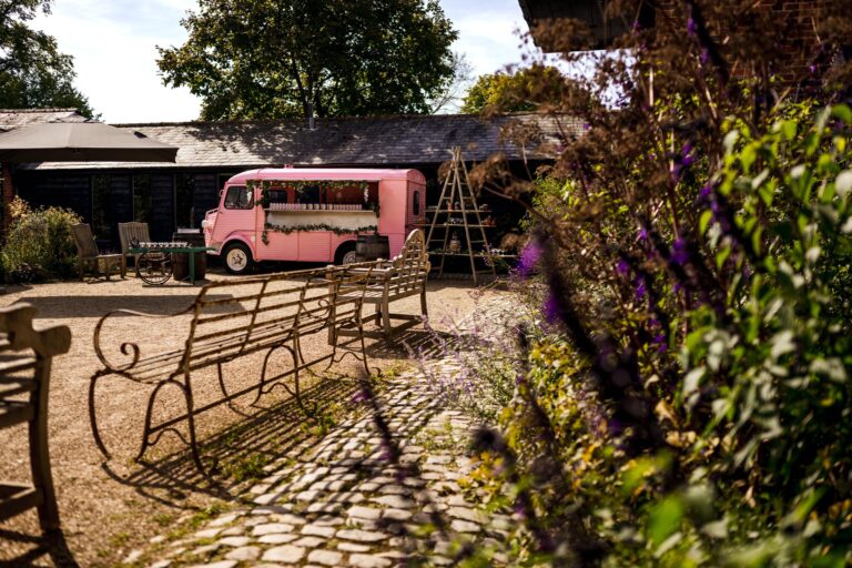 The cobbled courtyard with iron benches, lavender and a pink vintage van, Bury Court