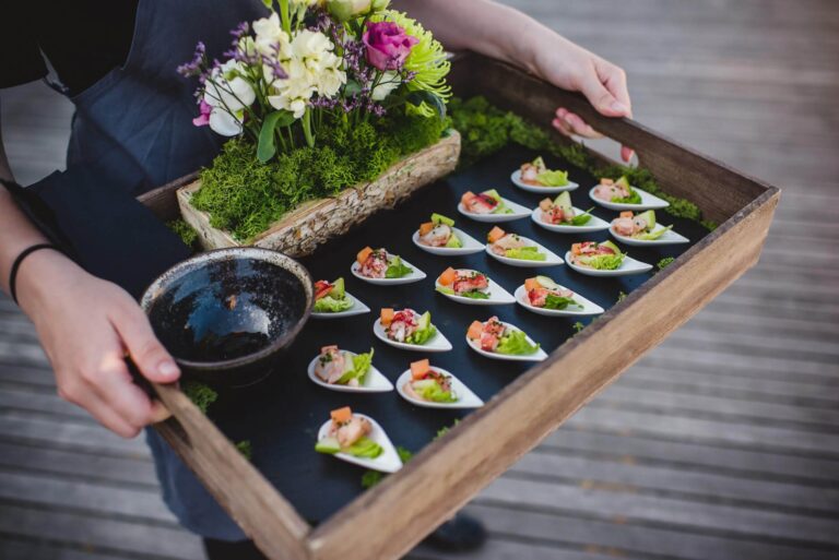 A tray of canapés in spoons, served with a moss and flower centrepiece, Bury Court