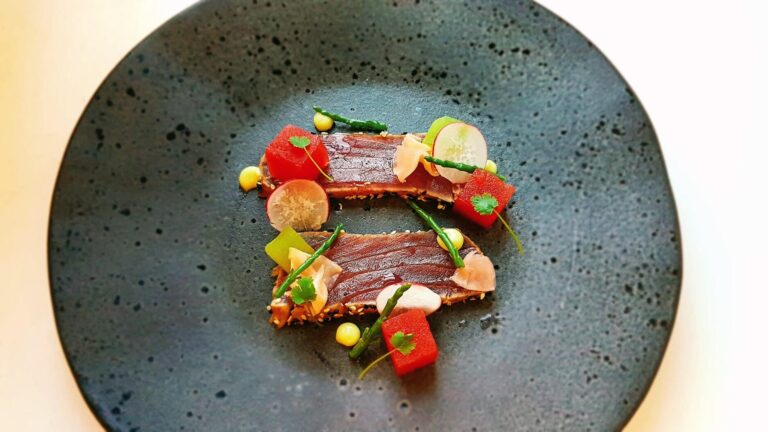 A plated starter with bright garnishes on a speckled grey plate, Bury Court