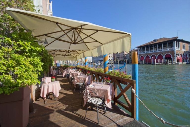 The canalside terrace, dining beneath umbrellas on the Grand Canal opposite the Rialto market, Ca' Sagredo Hotel