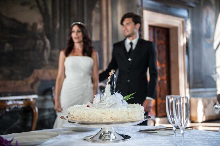 A couple cut the cake with the Grand Canal beyond the window, Ca' Sagredo Hotel