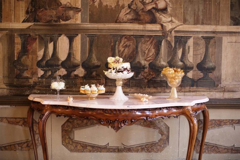 A dessert table set on the staircase landing among the sculptures, Ca' Sagredo Hotel