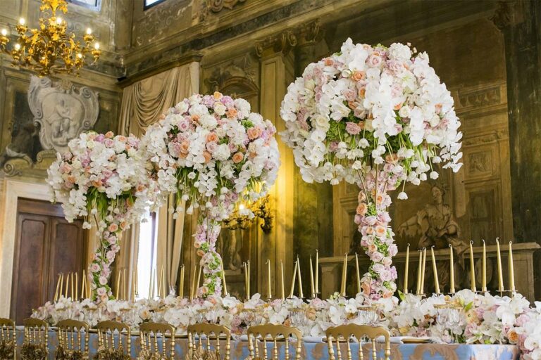 Tall floral centrepieces and candles dressing a frescoed salon for the celebration, Ca' Sagredo Hotel