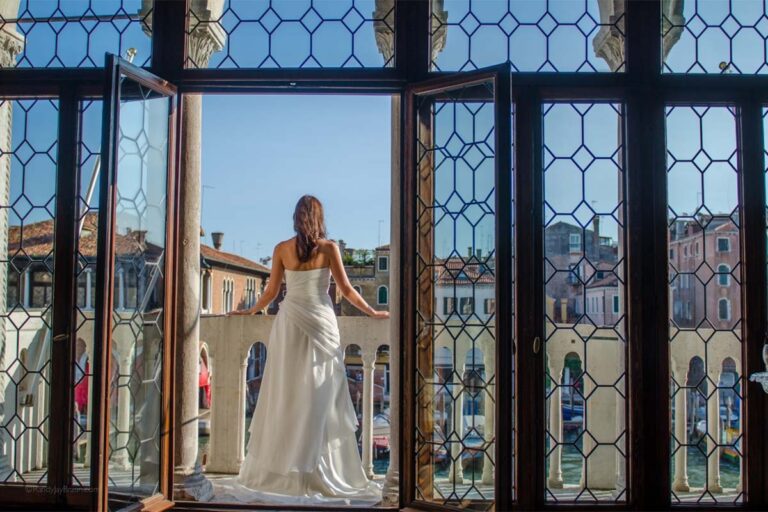 A bride at open Gothic windows above the Grand Canal, Ca' Sagredo Hotel