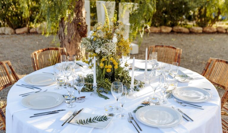 A wedding table set under the trees at Can Lluc, lit with string lights, Can Lluc Boutique Country Hotel