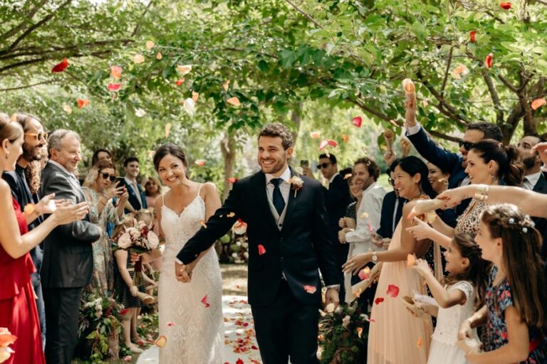 Guests throw petals as the couple walk through the gardens, Can Lluc Hotel