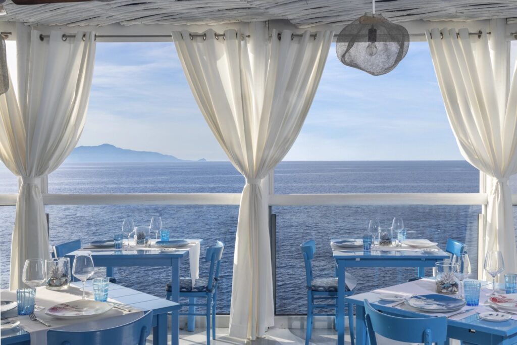 Restaurant terrace with curtains framing the sea, Capri Palace Jumeirah
