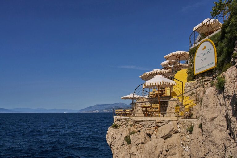 Beach club terraces and parasols on the cliff above the sea, Capri Palace Jumeirah