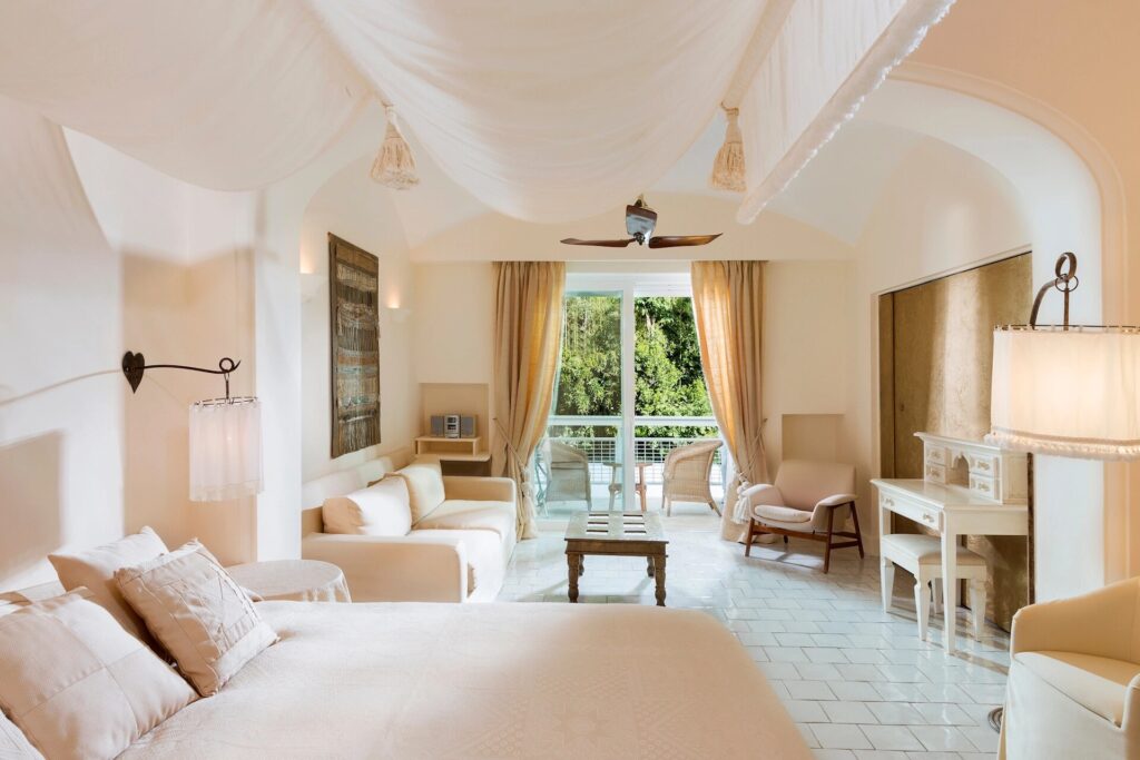 Bedroom with cream furnishings and a terrace door, Capri Palace Jumeirah