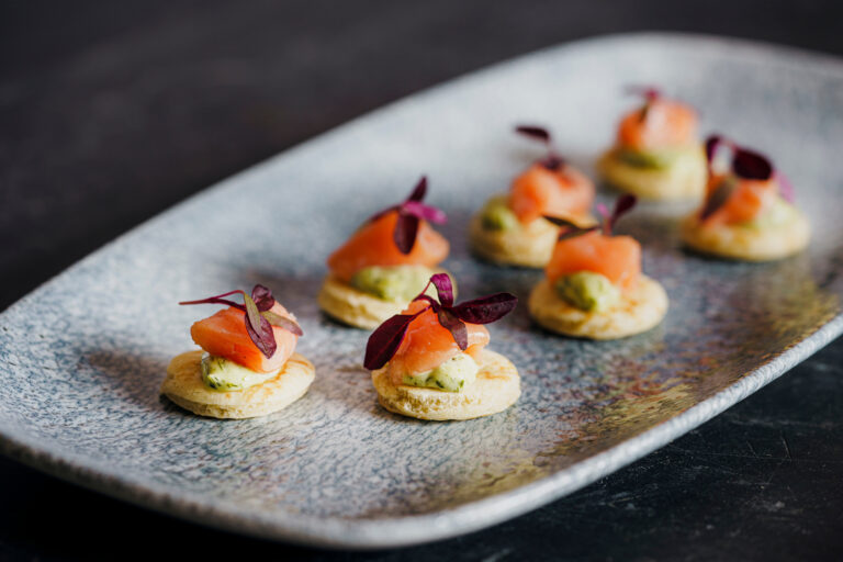 Smoked salmon canapes on blinis with a herb cream, set out on a grey stone platter, Captain's Club Hotel & Spa