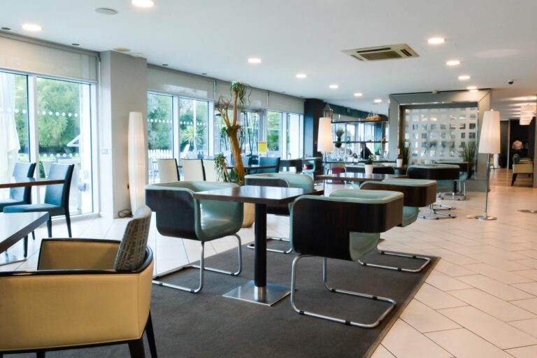 The Club Lounge with leather chairs and tables beside the glass wall to the terrace, Captain's Club Hotel & Spa